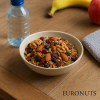 Ρεαλιστική φωτογραφία Fit Mix Ενέργειας Αθλητών EURONUTS σε μπολ, πάνω σε ξύλινο τραπέζι με μπουκάλι νερού, φρούτα ή αθλητικό εξοπλισμό, φυσικό φωτισμό, ιδανικό για υγιεινή διατροφή και ενέργεια.