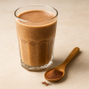 Smoothie με σκόνη γανόδερμα (reishi powder) σε γυάλινο ποτήρι με ξύλινο κουταλάκι δίπλα, premium παρουσίαση από EURONUTS superfoods για υγεία και ευεξία.