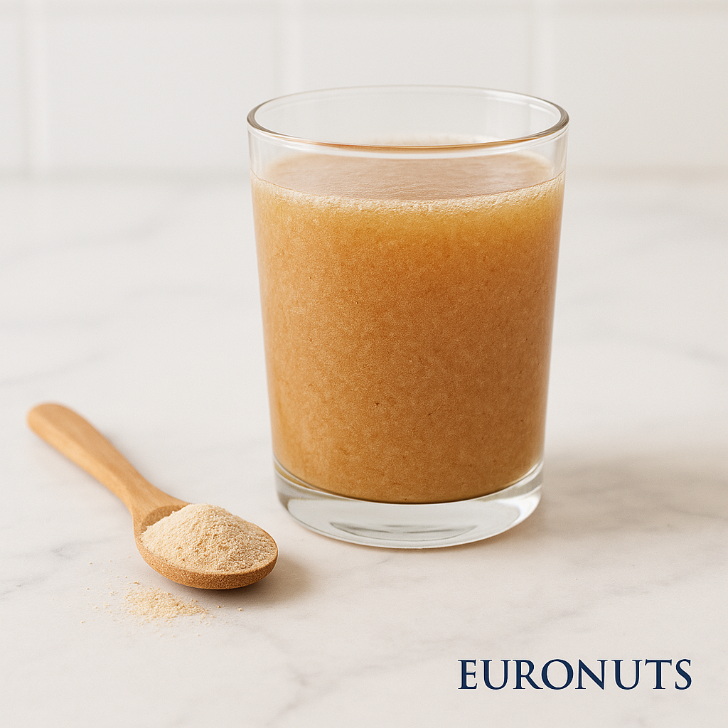 Σκόνη Ψύλλιου – Psyllium Husk Powder Fiber | Euronuts,Πάτρα Ένα ποτήρι νερό/ρόφημα με psyllium (φαίνεται πιο θολό/παχύρρευστο) + δίπλα ένα κουταλάκι με σκόνη, σε φωτεινή επιφάνεια, EURONUTS κάτω δεξιά
